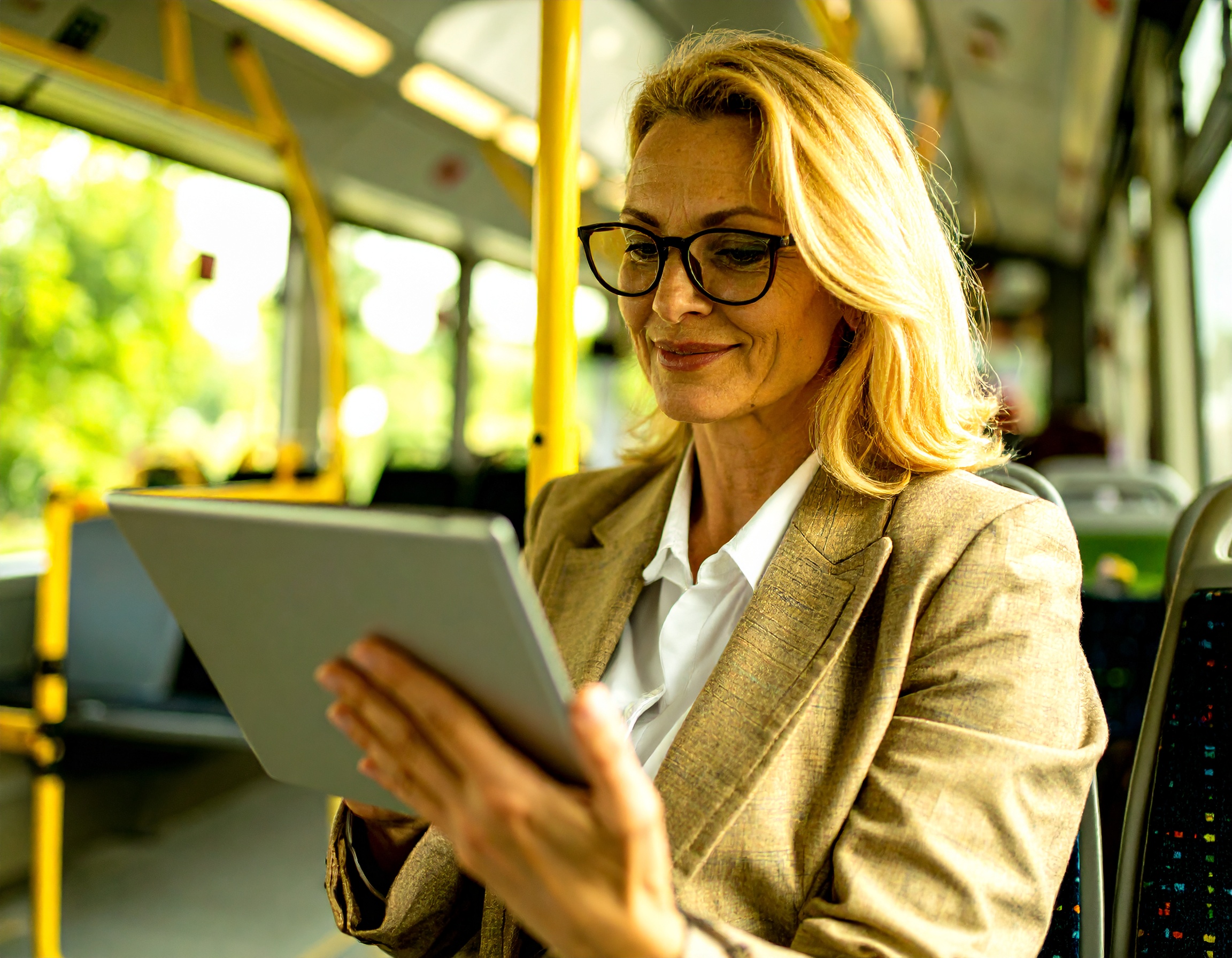 Frau liest DIE RHEINPFALZ auf einem Tablet w&auml;hrend einer Bus- oder Bahnreise.