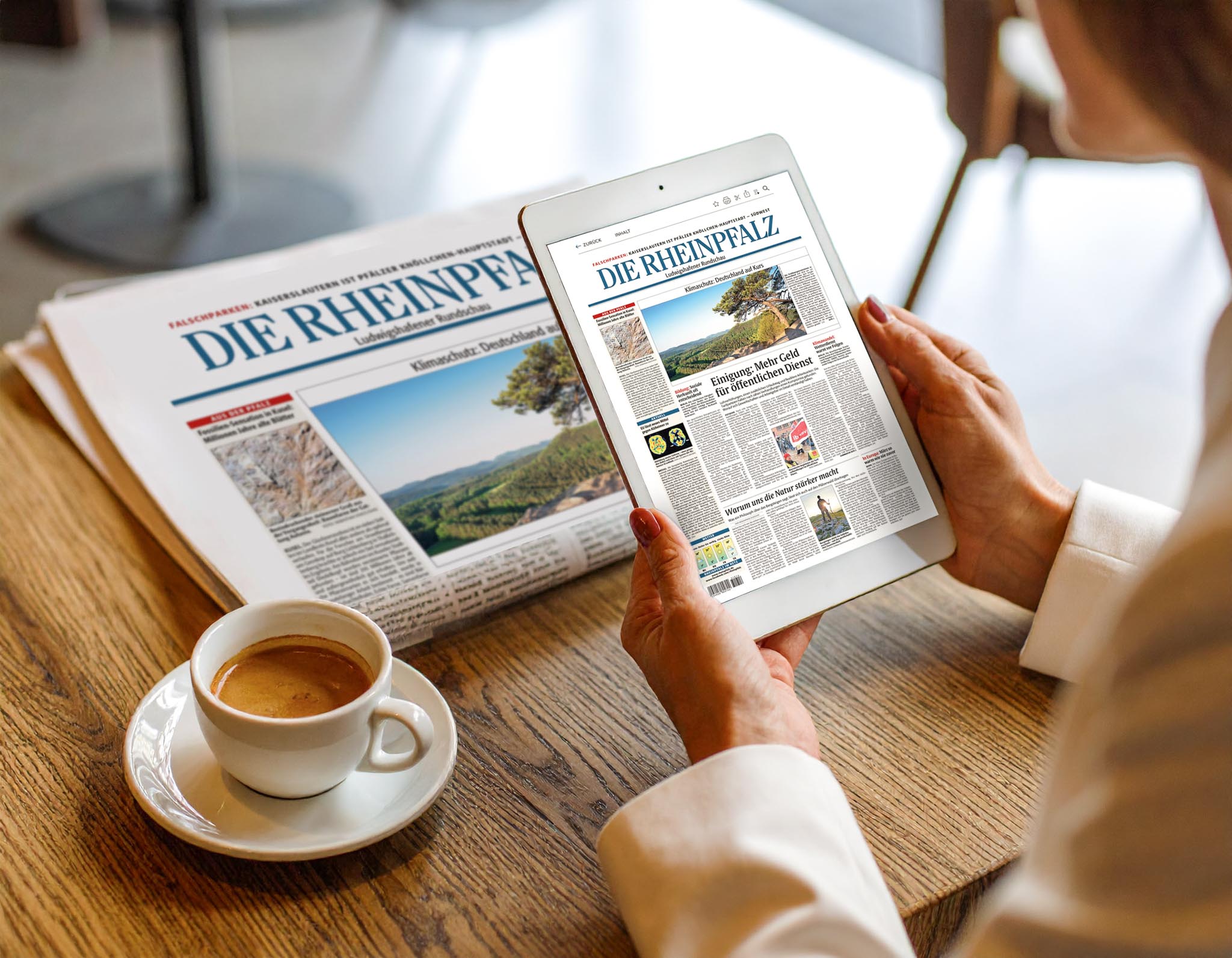 Person liest DIE RHEINPFALZ in gedruckter Form und auf einem Tablet bei einer Tasse Kaffee am Tisch