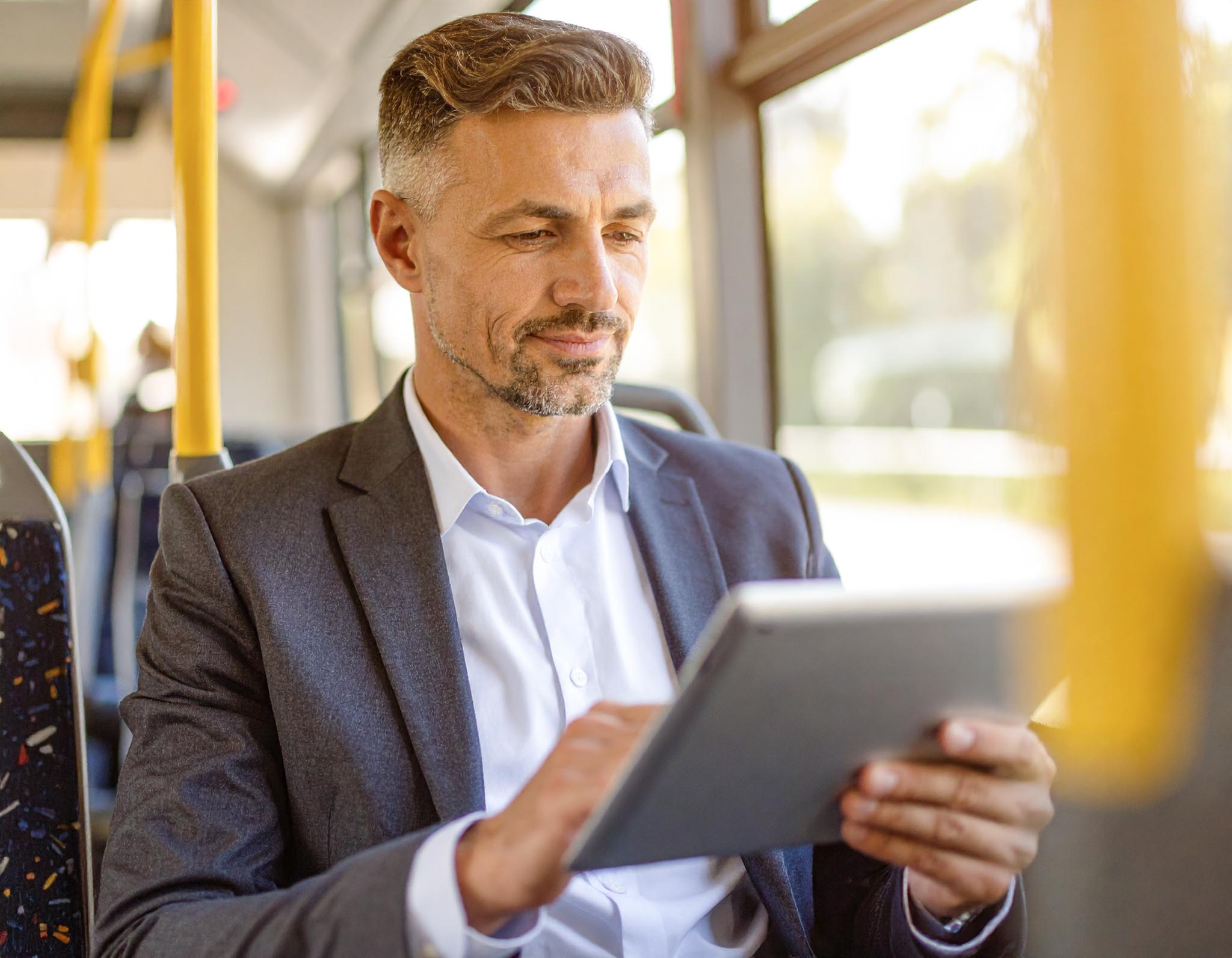 Mann liest auf einem Tablet im Zug &ndash; steht f&uuml;r flexiblen digitalen Zugang zur RHEINPFALZ-Zeitung unterwegs