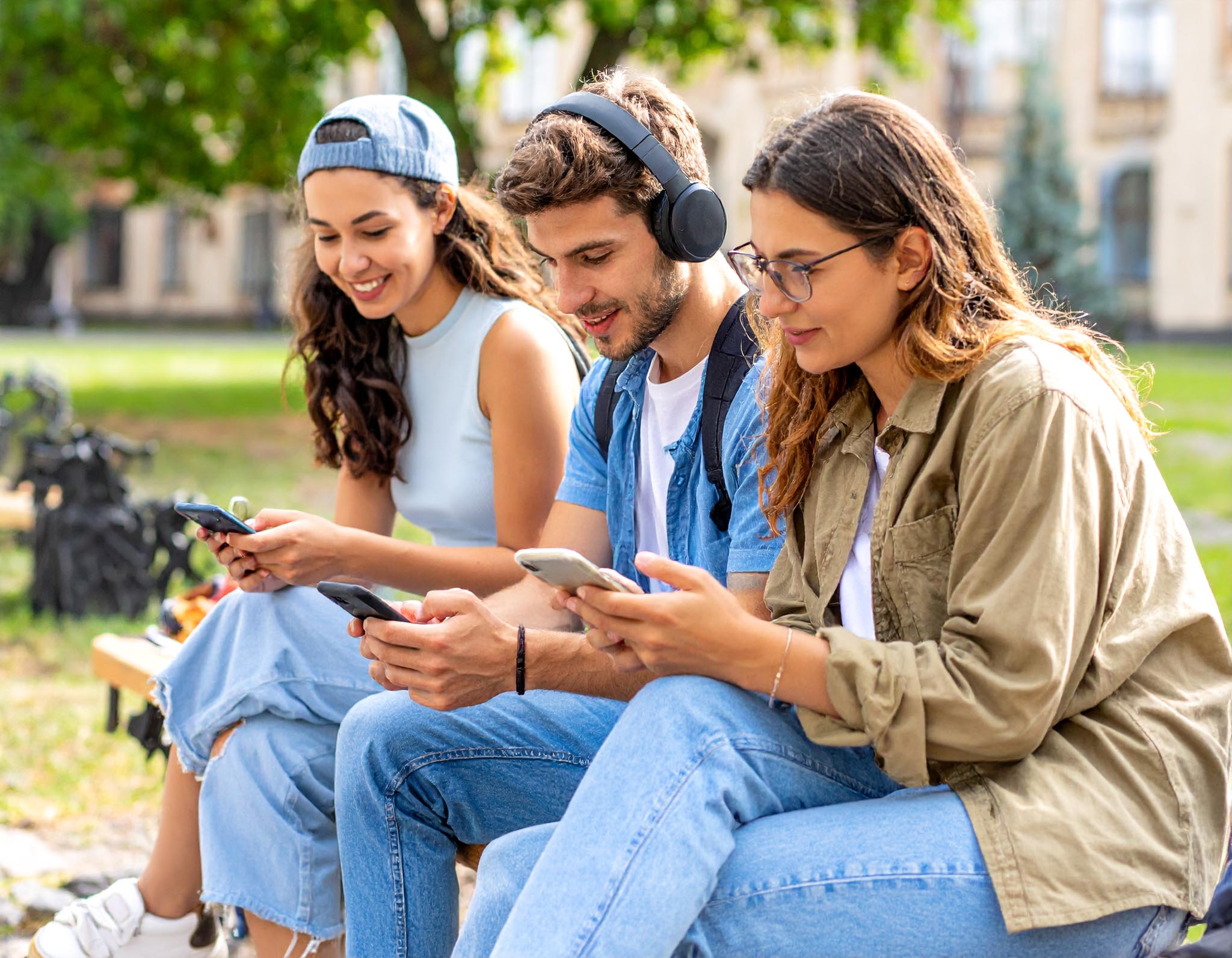 Drei Studierende lesen DIE RHEINPFALZ digital im Park &ndash; Darstellung des verg&uuml;nstigten Abo-Angebots f&uuml;r Studierende.
